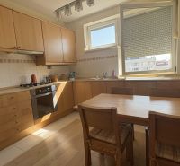 A kitchen in a 2-room apartment with a wooden decor and built-in appliances.