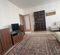 Living room in a two-room apartment with a wooden decor floor and comfortable furniture.