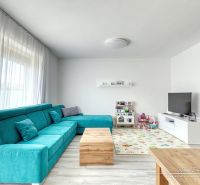 Living room in a family house with a turquoise sofa, television, and children's toys on Lipova Street.