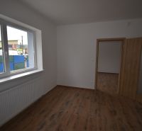 Interior of commercial spaces with wood-patterned flooring and a large window.