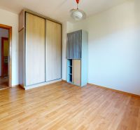 A room in a family house with a wooden decor floor and a built-in wardrobe.