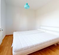 Bedroom in a family house with a bed and wooden decor flooring.