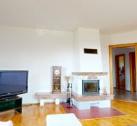 Living room in a family house with a stove and a television, floor with wooden decor.