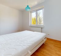 A bedroom in a family house with white walls and a wooden decor floor.