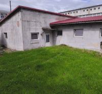 Warehouses and halls in Žiar nad Hronom with green lawns and gray facades.