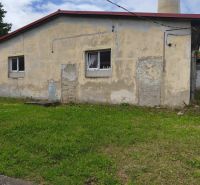 A building of warehouses and halls in Žiar nad Hronom with shabby walls and a grassy area.