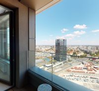 View from the balcony of a 2-room apartment to the panorama of Bratislava with glass railing.
