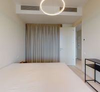 Bedroom in a 2-room apartment with curtains, central lighting, and a table.