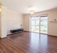 A room with a wooden decor floor and large windows in a family house.