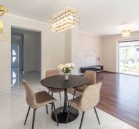 Dining room in a family house with a wooden decor floor and elegant lighting.