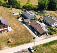 A top-down view of a row of family houses in Prestavlky with large gardens.