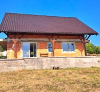 A family house in Prestavlky with an unplastered facade, surrounded by a lawn and nature.