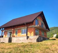 A family house in Prestavlky with an unfinished facade and a sloped roof on a gentle slope.