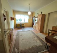 The interior of a family house with carpet, wood-patterned flooring, and wooden furniture.