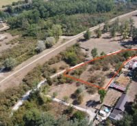Aerial view of recreational lands by the river in Piešťany, lined with trees.