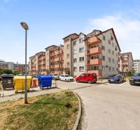 Don Sandtner Street in Pezinok with apartment buildings and a parking lot; ideal for a 2-room apartment.
