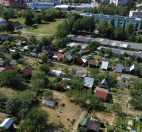 Garden colony in Detva with diverse cottages and gardens, surrounded by greenery and buildings.