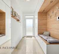 A hallway in a 3-room apartment with built-in seating and a floor with a wood decor.