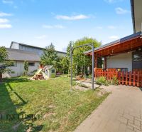 The yard of a 3-room apartment in Veľký Meder with a terrace, swing, and children's playhouse.