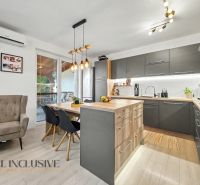 A kitchen in a 3-room apartment with a wooden decor floor, elegant lighting, and designer furniture.