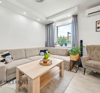 Living room in a 3-room apartment with a sofa, an armchair, and a table, light color palette.