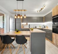 A kitchen in a 3-room apartment with gray cabinets and a wooden decor floor.