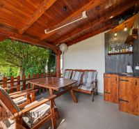 A wooden terrace with seating and a decorative structure in a 3-room apartment in Veľký Meder.