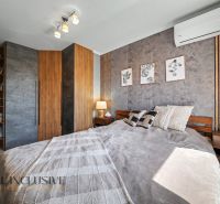 Bedroom in a 3-room apartment with a wood-patterned floor and air conditioning.