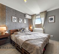 A bedroom in a 3-room apartment with textile decorations and a wooden decor floor.
