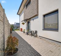 The exterior of a 3-room apartment in Veľký Meder with a paved terrace and flower pots.