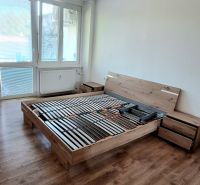 Bedroom in a 2-room apartment with a bed and a floor with a wooden decor.
