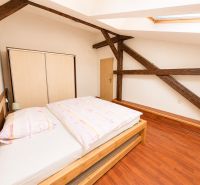 Bedroom in a 3-room apartment with a wooden decor floor and a skylight.