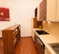 Kitchen in a 3-room apartment with wood-patterned flooring and storage spaces.
