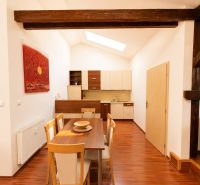 A dining room with wooden decor and beams in a 3-room apartment.