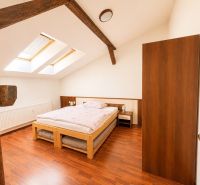 A bedroom with a bed and a wooden decor floor in a 3-room apartment.