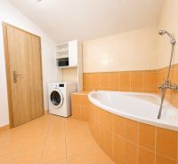 A bathroom in a 3-room apartment with a bathtub and a washing machine.
