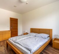 Bedroom with a bed and a dresser in a Holiday Apartment, floor with wooden decor.
