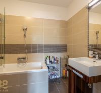 Bathroom in a holiday apartment with a bathtub and a sink on ceramic tiles.