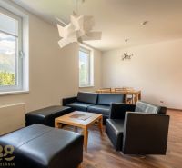 Interior of a holiday apartment with sofas, a dining table, and a wooden decor floor.