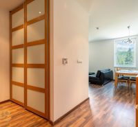 Interior of a holiday apartment with wood-patterned flooring and a view of nature.
