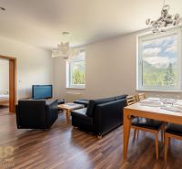 Living room of a holiday apartment with wood-patterned flooring, mountain view.
