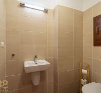 Bathroom in a Holiday Apartment with beige tiles and a wall-mounted sink.