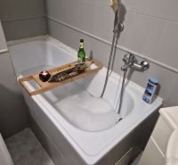A bathroom in a 3-room apartment with a bathtub and bathroom accessories.
