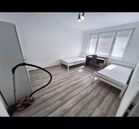 A bright room with two beds and a wooden decor floor in a 3-room apartment.