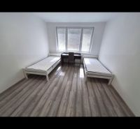 Two beds with mattresses in the bedroom of a 3-room apartment with a wooden decor floor.