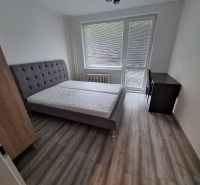 A bedroom in a 3-room apartment with a bed and a floor with a wooden decor.