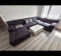 Corner sofa with a table in a 3-room apartment on a floor with a wood decor.