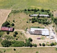 Fields and abandoned buildings surrounded by greenery in Stará Turá. Unusual properties.