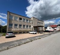 An office building in Stará Ľubovňa with a parking lot and a clear sky.