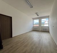 Offices with a bright interior and wood-decor flooring, equipped with large windows.